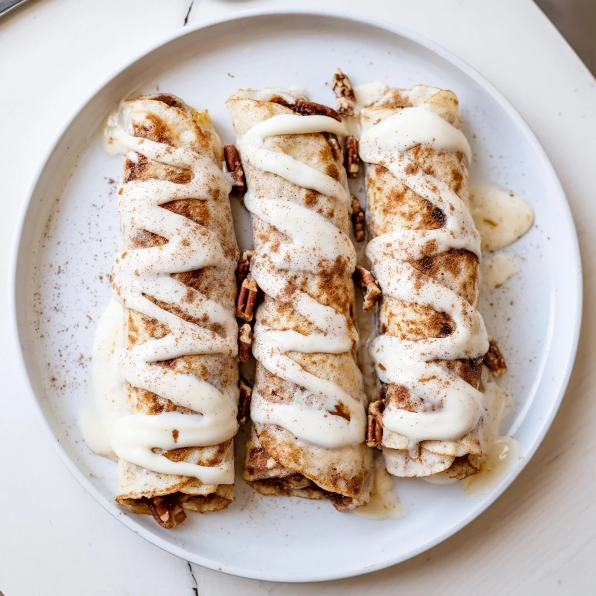 Golden cinnamon roll protein crepes folded into quarters with a sweet cinnamon sugar filling