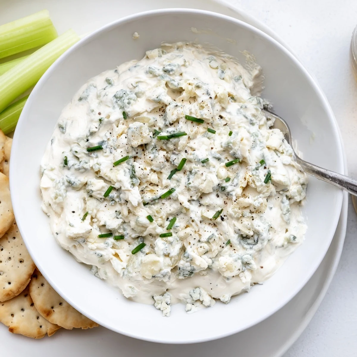 Thick blue cheese dip topped with crumbled cheese and fresh chives, served chilled