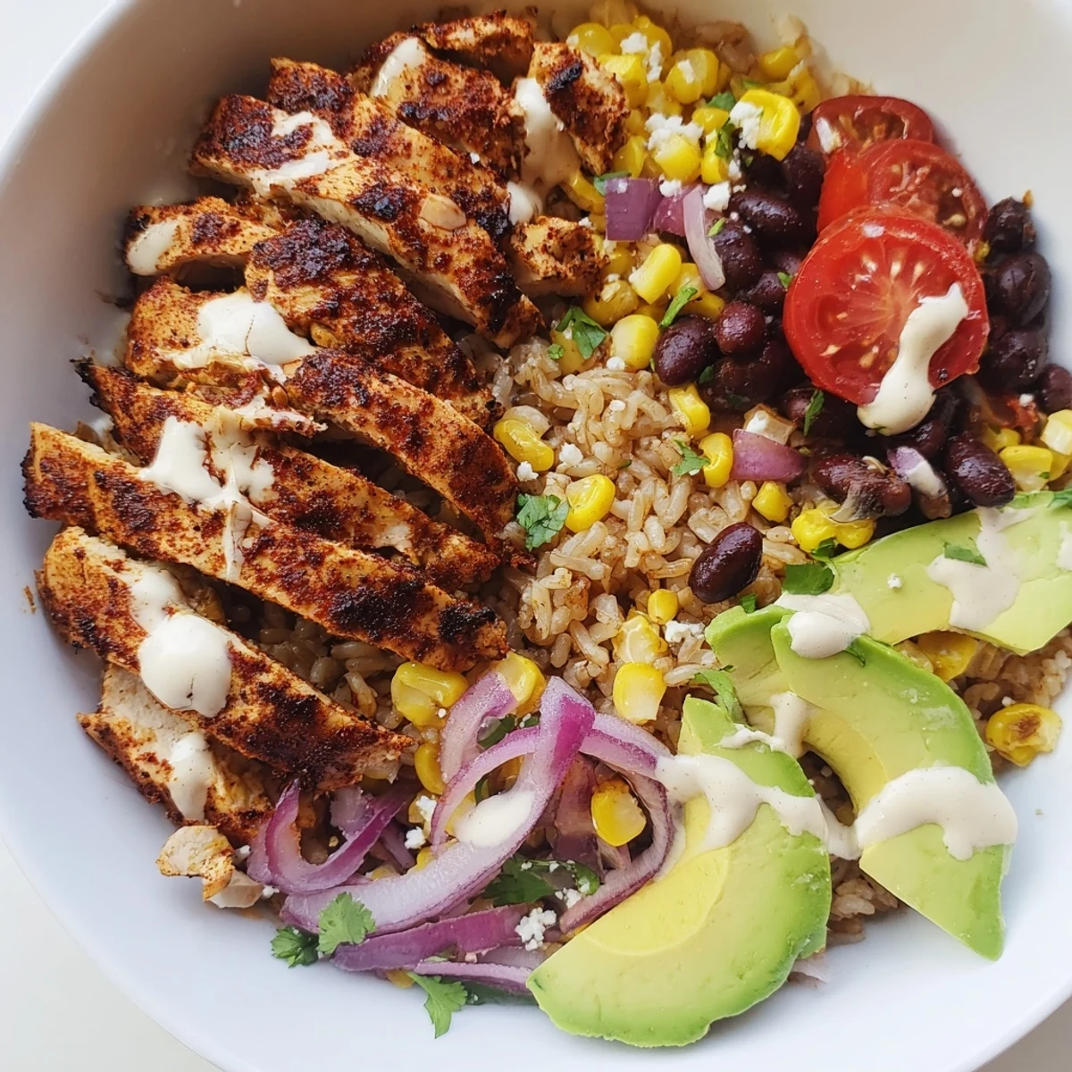 Vibrant Healthy Street Corn Chicken Bowl drizzled with tangy cotija sauce and lime wedges