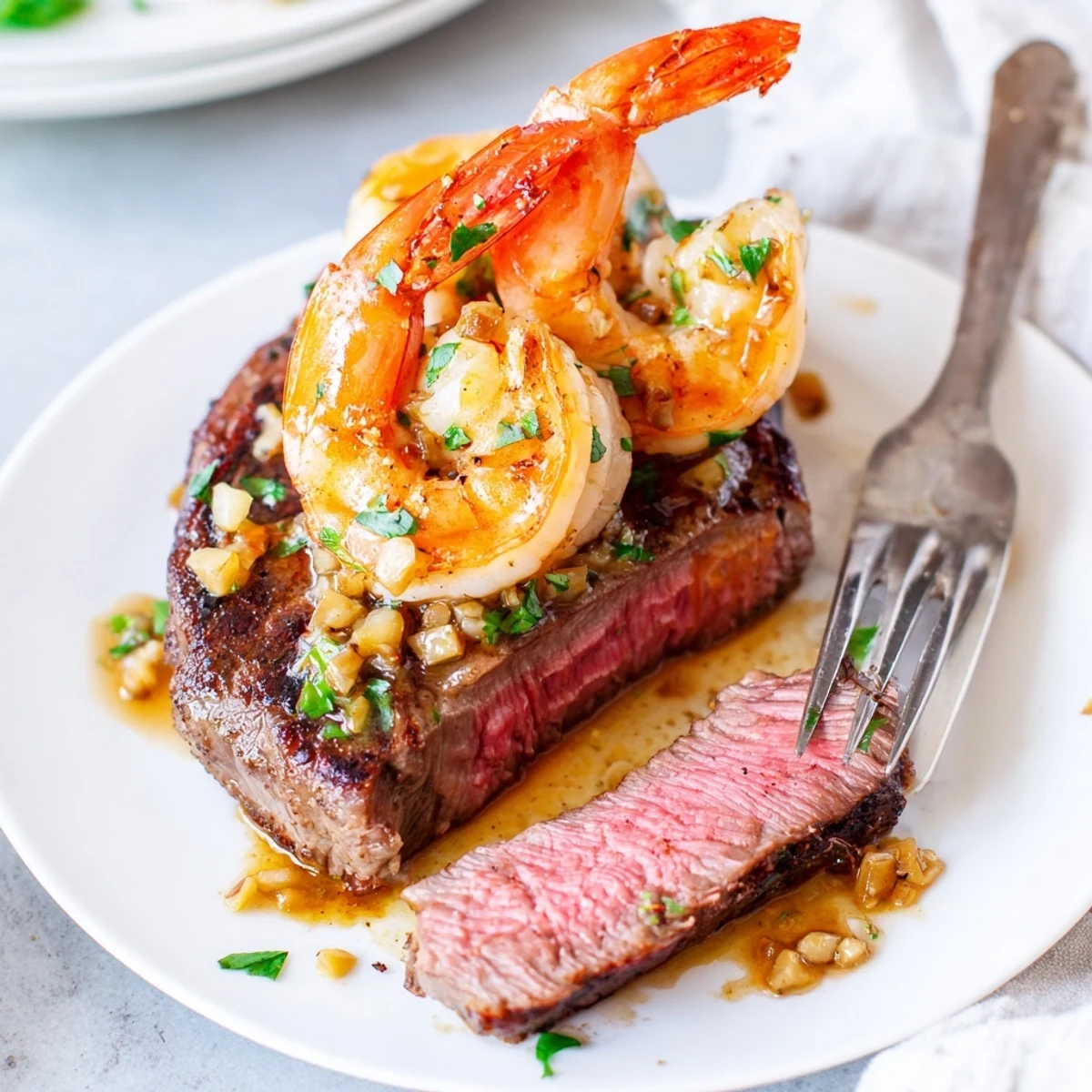 Succulent steak and garlic butter shrimp drizzled with rich pan sauce and parsley
