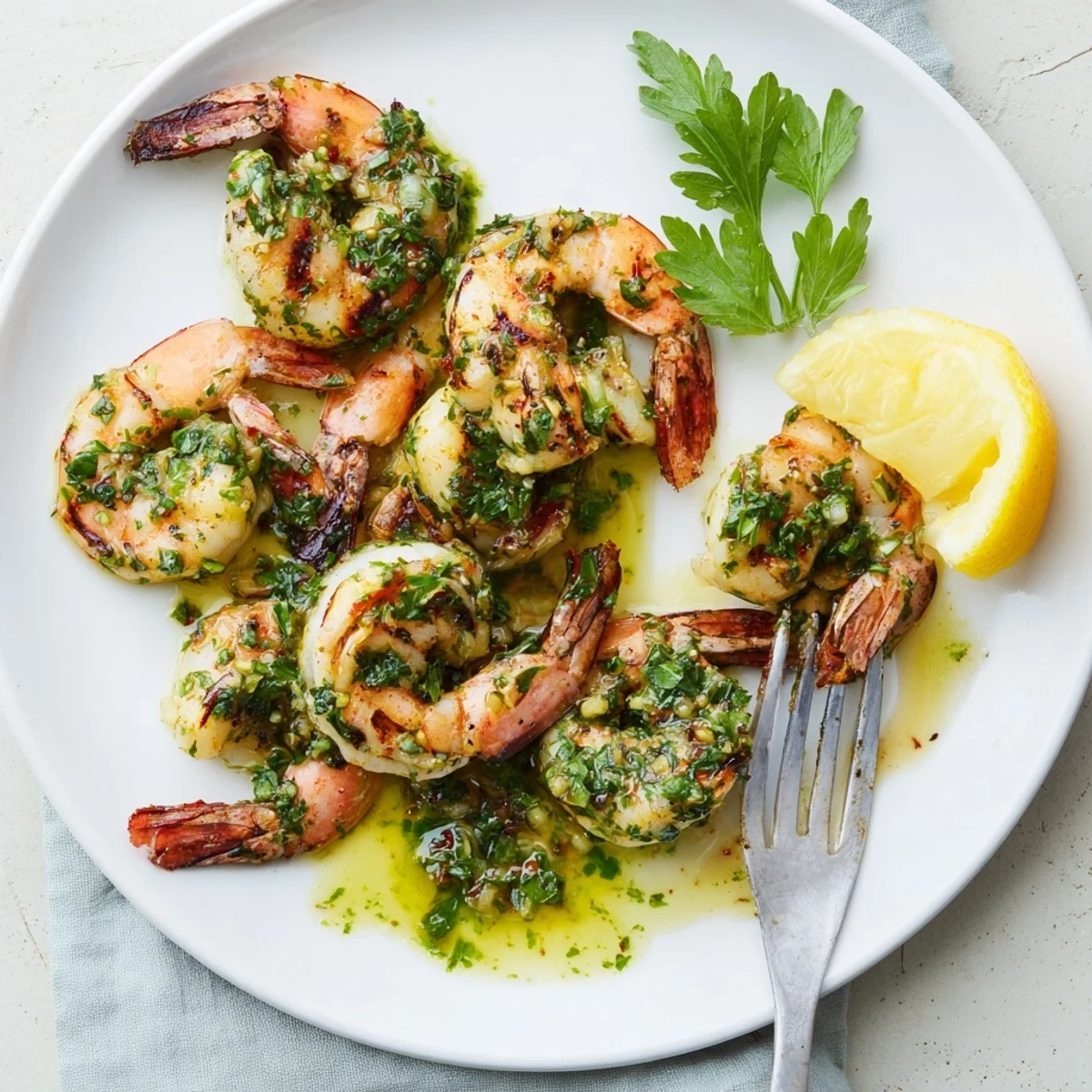Golden grilled chimichurri shrimp garnished with fresh parsley and lemon wedges