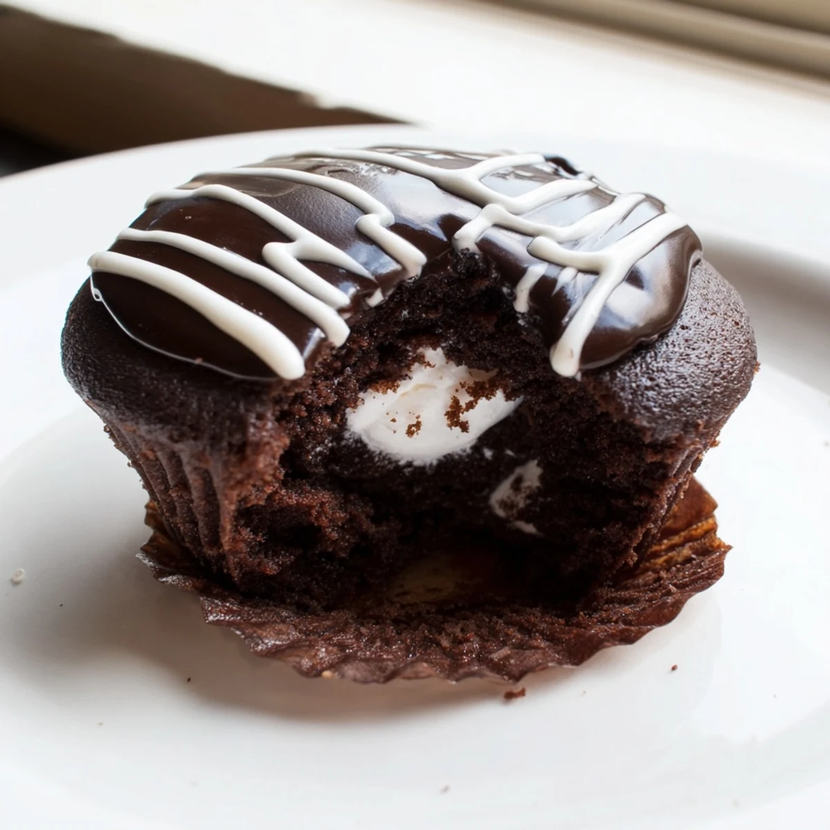 Homemade Hostess Cupcakes arranged on a plate with rich chocolate ganache coating