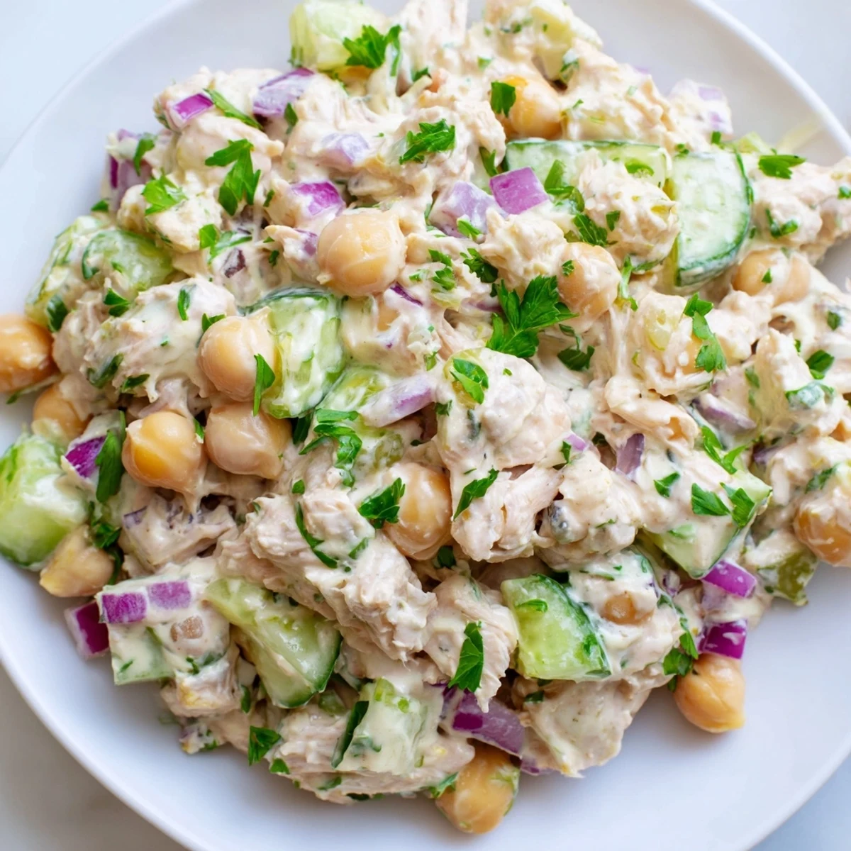 Creamy tuna chickpea cucumber salad served in a rustic bowl with fresh herbs