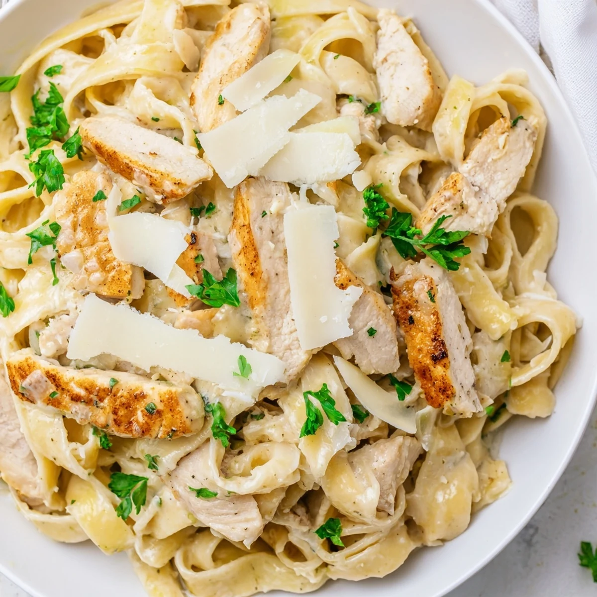 Golden seared chicken pieces nestled in Creamy Garlic Parmesan Chicken Pasta with fettuccine