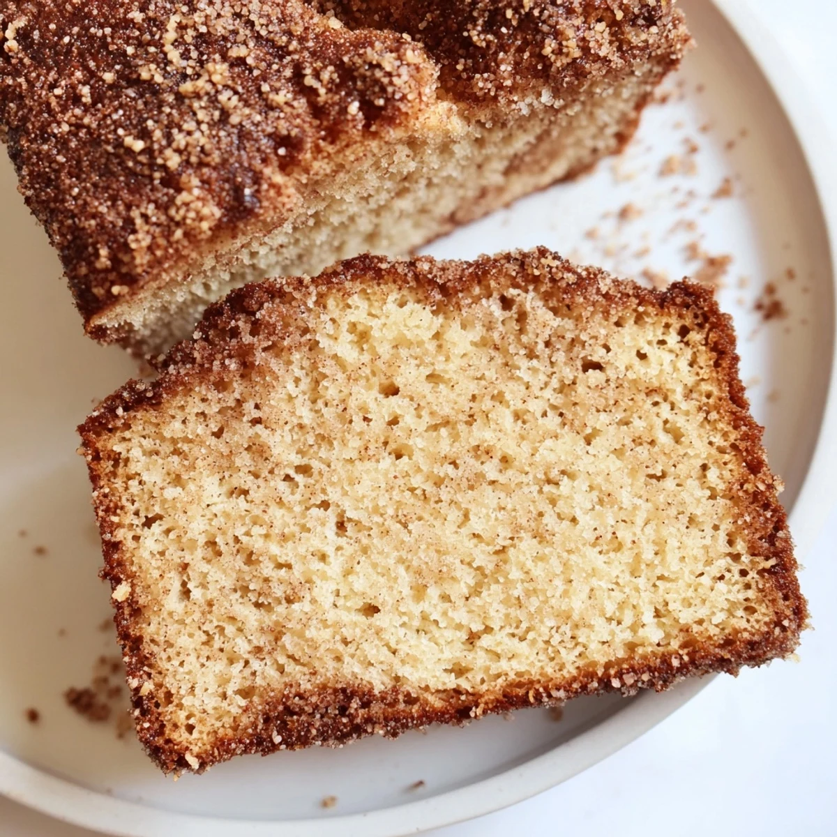 Warm cinnamon donut loaf sliced thick with a golden cinnamon-sugar crust
