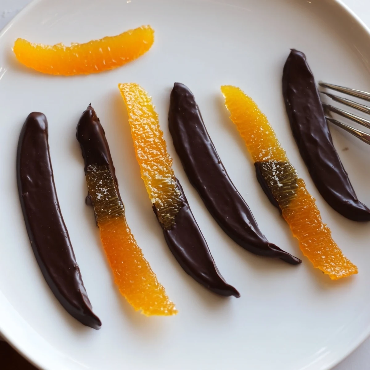 Candied chocolate covered orange peels glistening with smooth melted dark chocolate finish