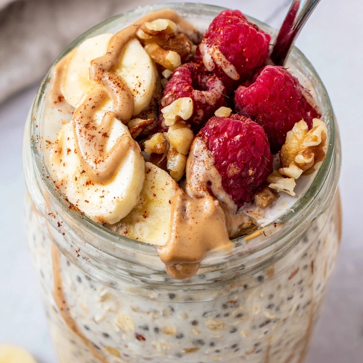 Protein overnight oats served with sliced banana and a drizzle of almond butter