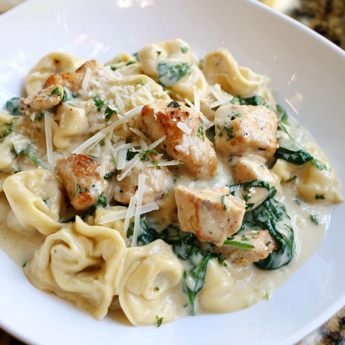 Creamy Garlic Chicken Tortellini with Spinach served in a rustic white bowl