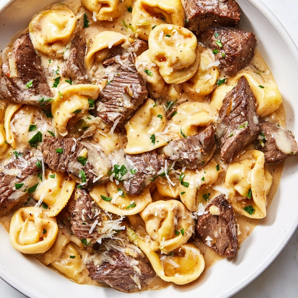 Garlic Steak Tortellini in creamy Parmesan sauce with seared sirloin bites and fresh parsley