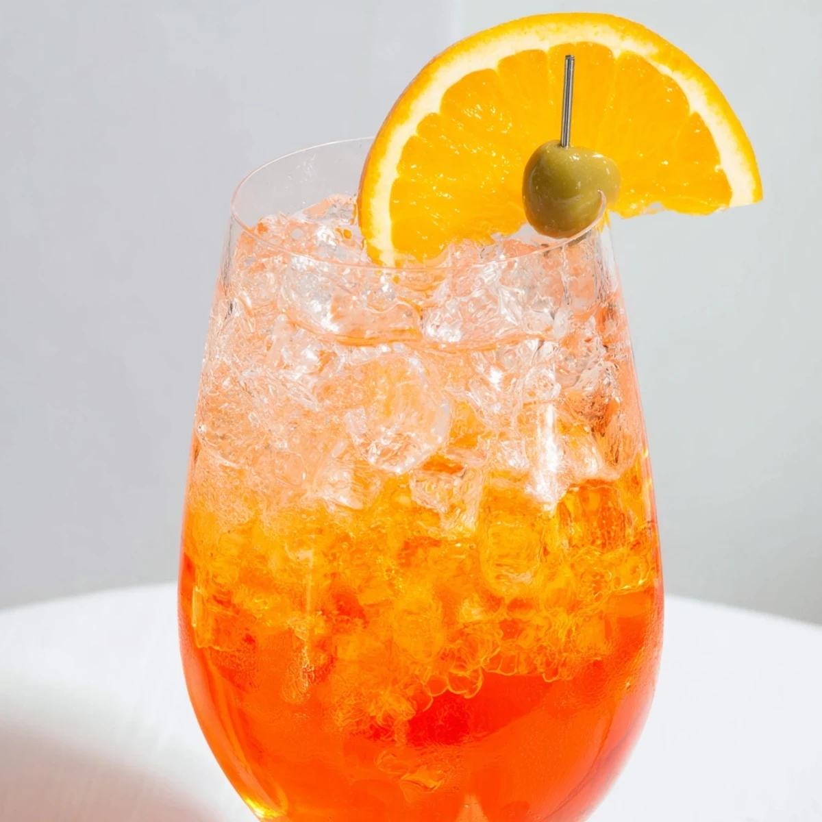 Glass of sparkling Spritz cocktail with bubbles and an orange wheel.  