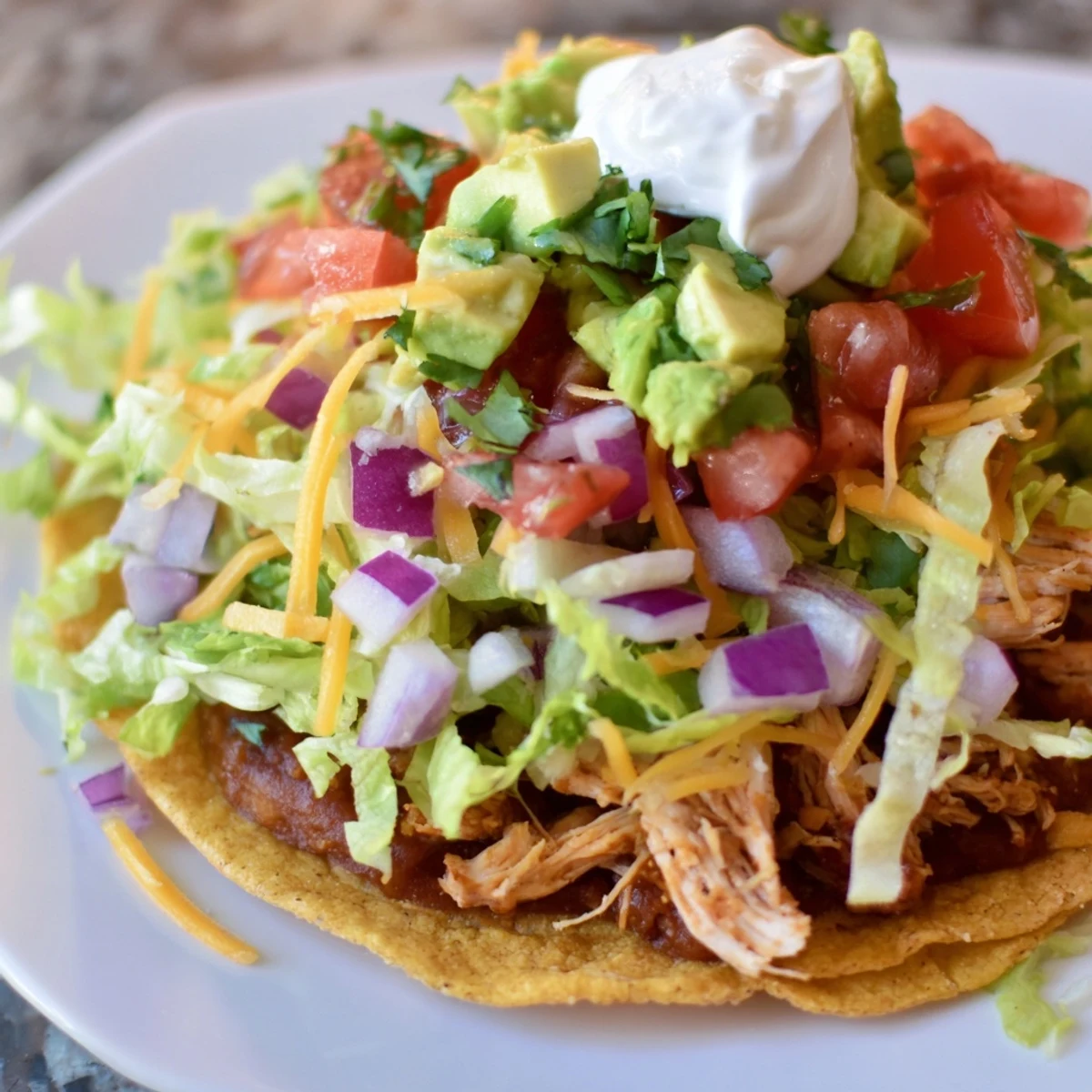 Golden crispy Chicken Tostadas loaded with seasoned chicken and fresh colorful toppings  