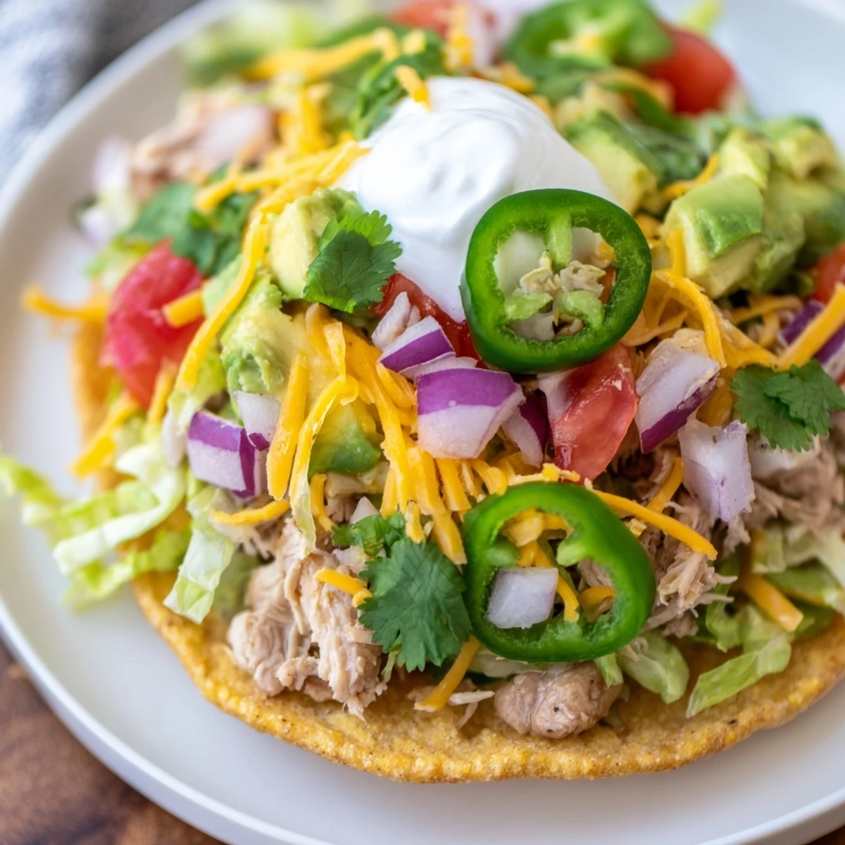 Golden crispy chicken tostadas loaded with fresh veggies and creamy toppings.  