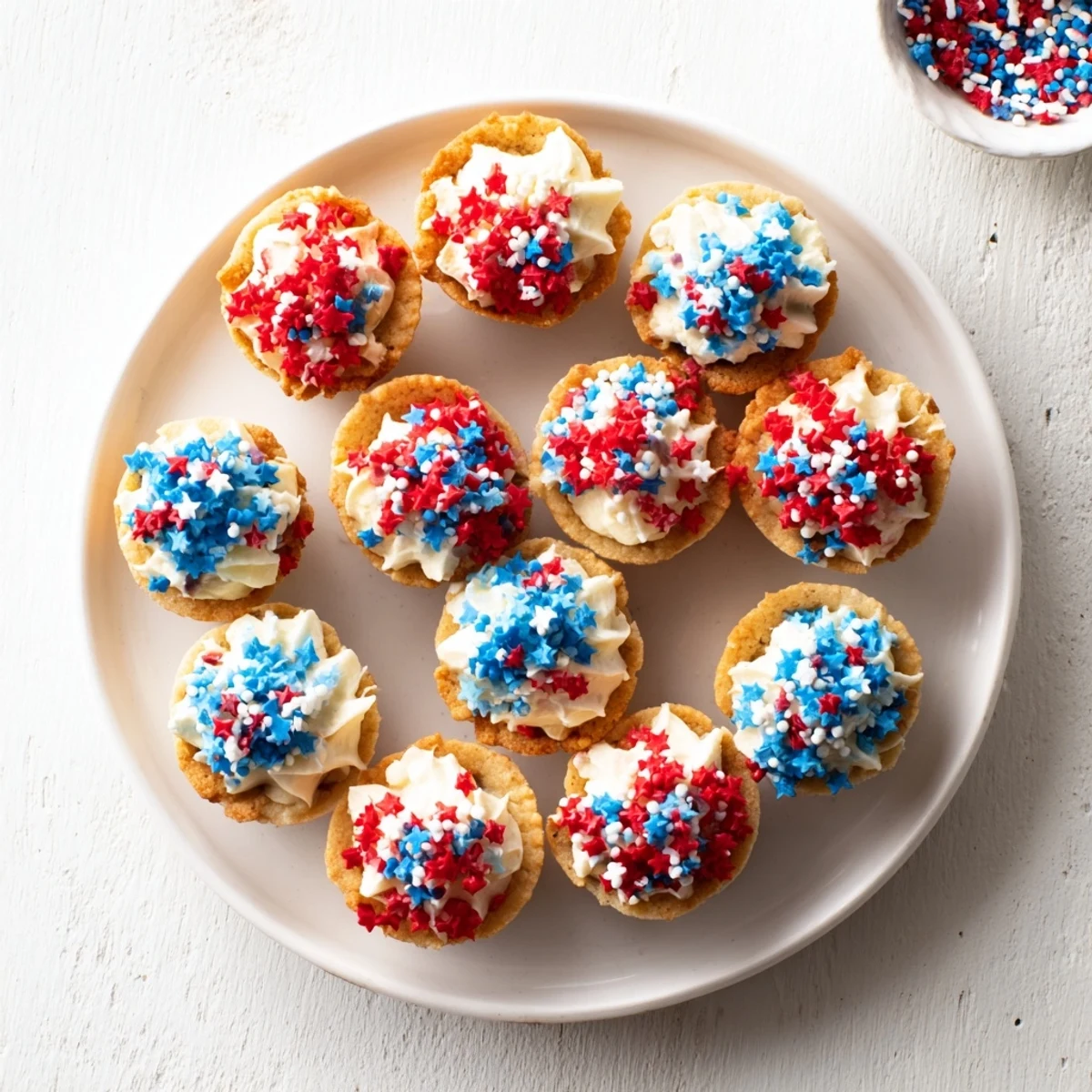Golden patriotic chocolate chip cookie cups filled with creamy buttercream and festive sprinkles.  