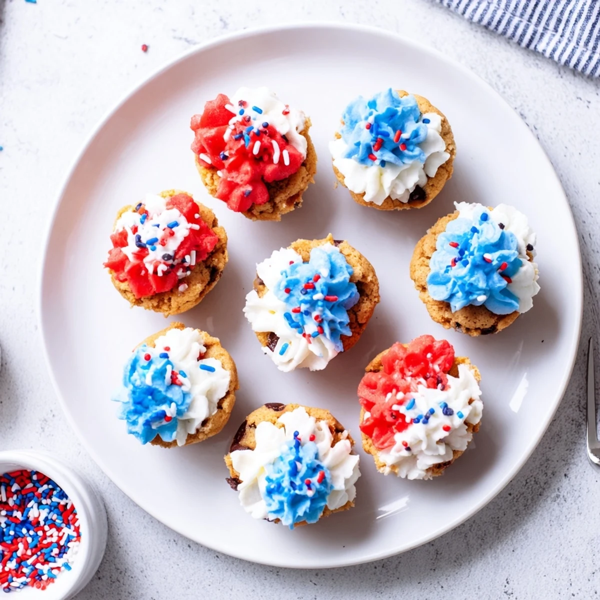 Delicious patriotic chocolate chip cookie cups decorated with swirls of red, white, and blue frosting.