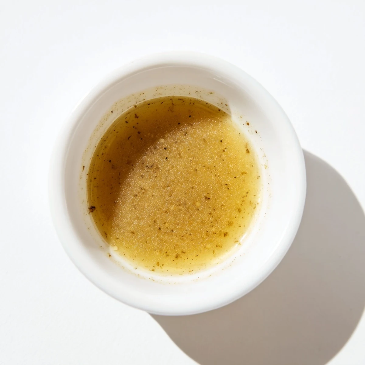 Golden honey vinaigrette drizzled over fresh greens with a glossy sheen  