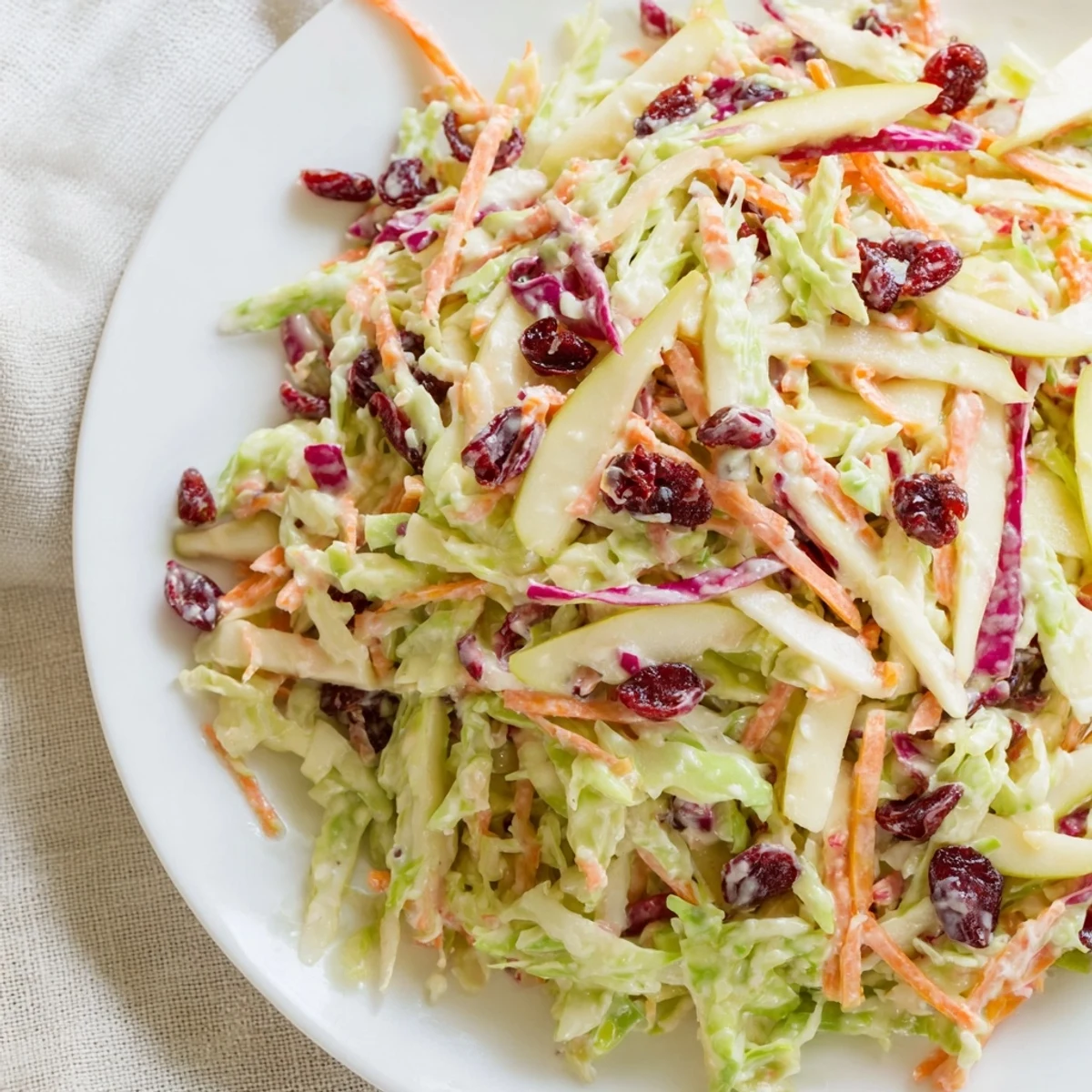 Vibrant cranberry apple coleslaw with crunchy cabbage and sweet apples in a bowl.